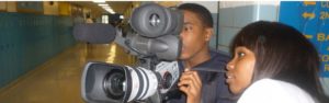 A man is holding a video camera up to his face.