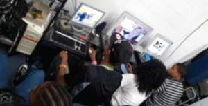 A group of people sitting around a computer.