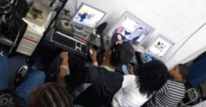 A group of people sitting around in front of tv.