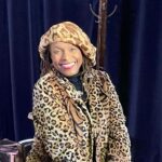 A woman in leopard print coat and hat.