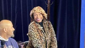 A woman in leopard print coat and hat.